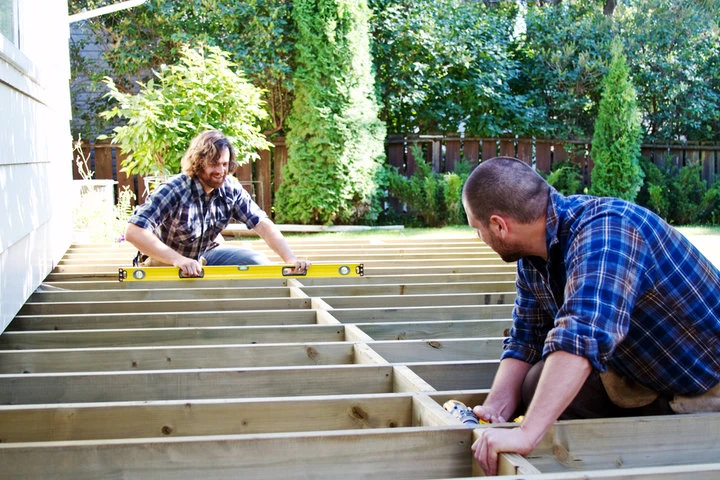 Deck builders reinforcing the structural framework of a residential custom deck in Sacramento